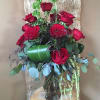 Red roses with eucalyptus and green accents. This beautiful arrangement evokes the