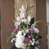 Arrangement with lilies and hydrangeas in purple and white hues. 