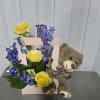 A cheerful  mix of bright yellow roses and vibrant blue 