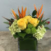 A modern design featuring Bird of Paradise, yellow roses, green hydrangeas, and