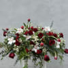 A full casket spray of roses, mums, foliages, orchids, tulips overflowing and