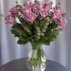 Lavander/ deep purple roses with spiral eucalyptus in a clear vase