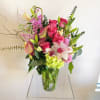 A tropical arrangement filled with tropical florals like cymbidium orchids, fresh pinks
