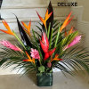 Tropical arrangement arranged in a vase.
Deluxe has more tropical flowers and greens