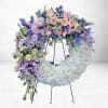 The Whispering Skies Wreath is a serene and ethereal floral tribute, artfully