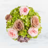 This vintage style arrangement contains roses, hydrangea, and a succulent. It is