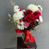 Mix of red and white flowers in a clear vase. 