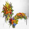 The Garden Glory Tribute Set is a vibrant three-piece funeral floral collection