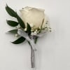 A timeless boutonni&egrave;re featuring a single, pristine white rose, delicately accented with