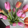 An arrangement of tulips carefully placed in a vase, highlighting their natural