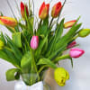 An arrangement of tulips carefully placed in a vase, highlighting their natural