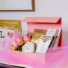 A delightful gift box featuring gourmet treats, delicate blooms, and elegant gold