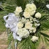 In stock white flowers and greens arranged beautifully on a standing spray