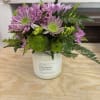 A 16 oz 100% natural soy wax candle with a floral arrangement