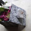 This cute arrangement is arranged in a natural granite box with Crystal