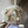 A delicate bouquet in soft peach and ivory tones, featuring elegant ranunculus