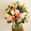 A colorful arrangement made of roses, pink lilies and purple lisianthus and