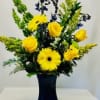 Yellow gerbers, yellow roses, solidago and blue delphinium combined in a blue