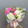 A curated mix of pink and white lilies, roses, carnations, and spider