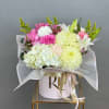 A curated mix of pink and white lilies, roses, carnations, and spider