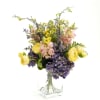 An arrangement of artificial flowers in a modern square vase.