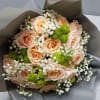 Phoenix Cushions is a wrapped bouquet designed of peach roses, green chrysanthemum