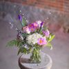 Beautiful budding iris blooms emerge from garden flowers arranged in a rectangular
