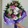 Roses, daisies, alstroemeria, with greenery and babies breath wrapped in paper with