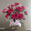 A stunning floral arrangement of 24 long stem fuchsia roses, baby&rsquo;s breath