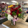 Beautiful and delicate floral arrangement in medium-sized glass cylinder, with roses mini