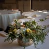 A lush green centerpiece with bright accents from seasonal flowers. 