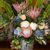 A grand bouquet of protea with other seasonal flowers that have soft