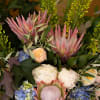 A grand bouquet of protea with other seasonal flowers that have soft
