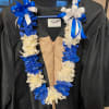 The Lei is made with rose petals and braided ribbons.
