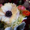 A lush arrangement with rose and plum colored flowers. 