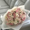 A graceful bouquet of creamy white and soft blush roses, elegantly wrapped