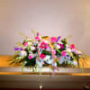 This is a large full casket spray with orchids and lilies and