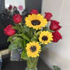 Sunflowers (two different sizes), red roses, greenery and clear vase. 