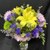Vase filled with yellow siatic lilies, lavender daisies and limonium, purple statice