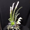 All white high style arrangement calla lilies, dianthus, thisel with mixed eucaliptus