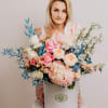 A mix of fresh flowers including different types of roses, hydrangeas, delphinium