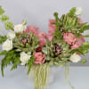 A bold, textural blend of artichokes, blush roses, ivory spray roses, and
