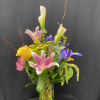 vase filled with white calla lilies, yellow roses purple irises, pink stargazers