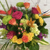 Tropical birds of paradise mixed with vibrant roses, bright orange lilies and