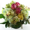 A tropical and classic bouquet of fresh flowers in clear vase, with