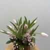 This arrangement features pink tulips and pink baby breath with ruscus detailing