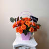 A vibrant and elegant arrangement featuring fresh mini roses and eucalyptus, designed