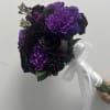 Features purple carnations, black roses, lavender stock, and purple scabiosa wrapped in
