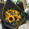 This bouquet features sunflowers, purple aster detailed with ruscus. 