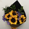 This arrangement features sunflowers, purple aster, and ruscus. 
